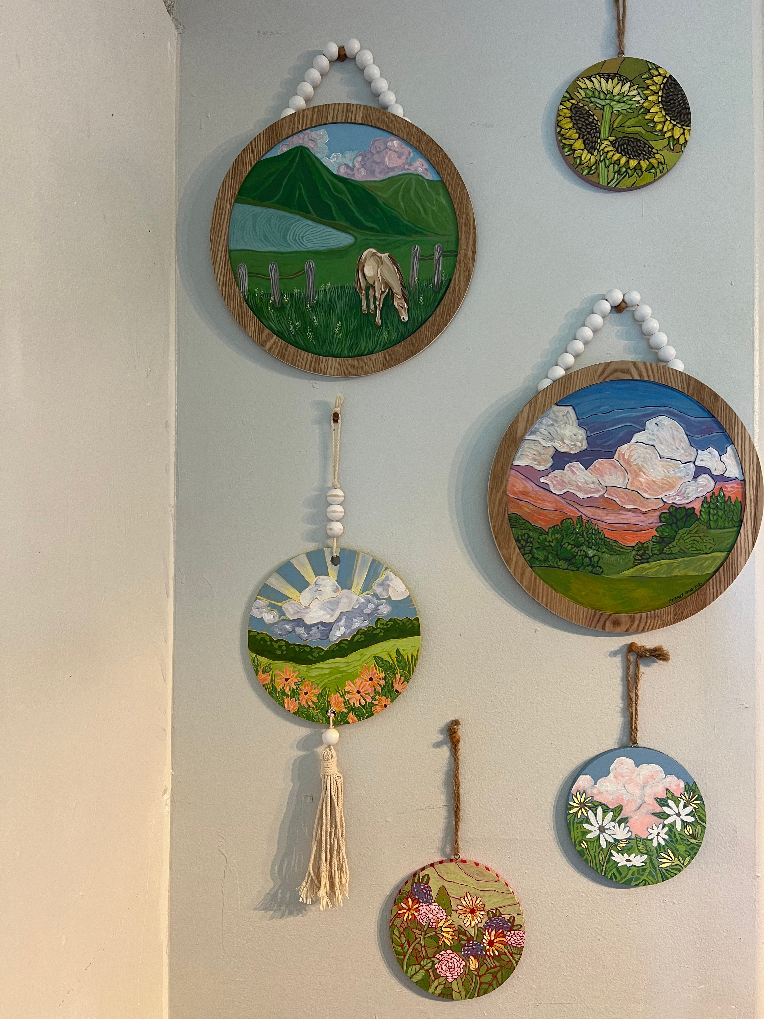 several different painted wooden wall hangings